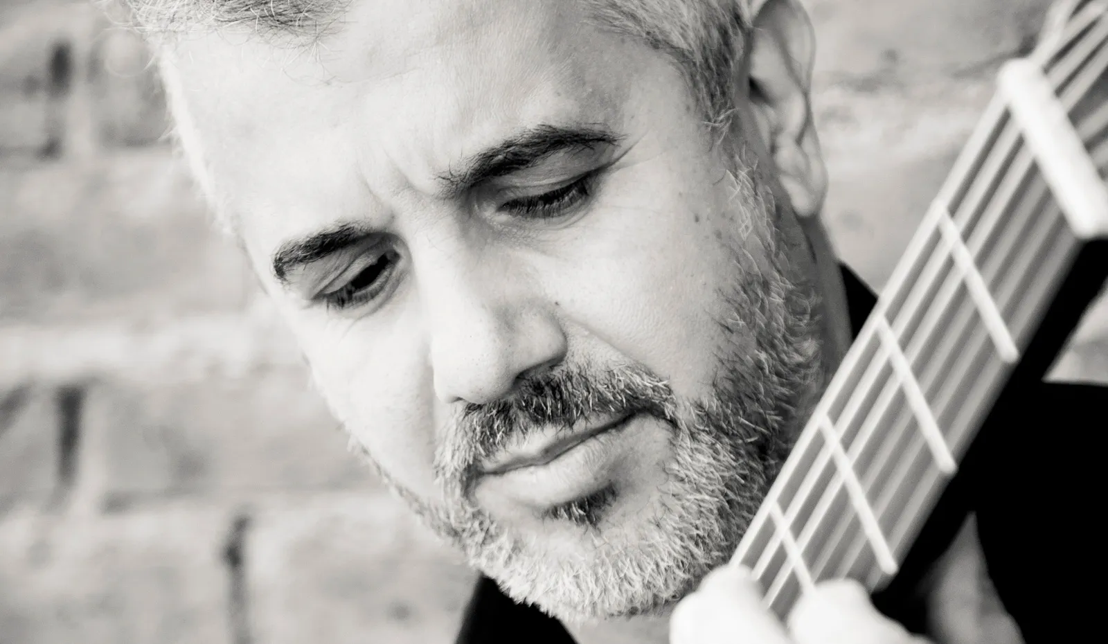 Roberto Calvo tocando la guitarra, mirando las cuerdas